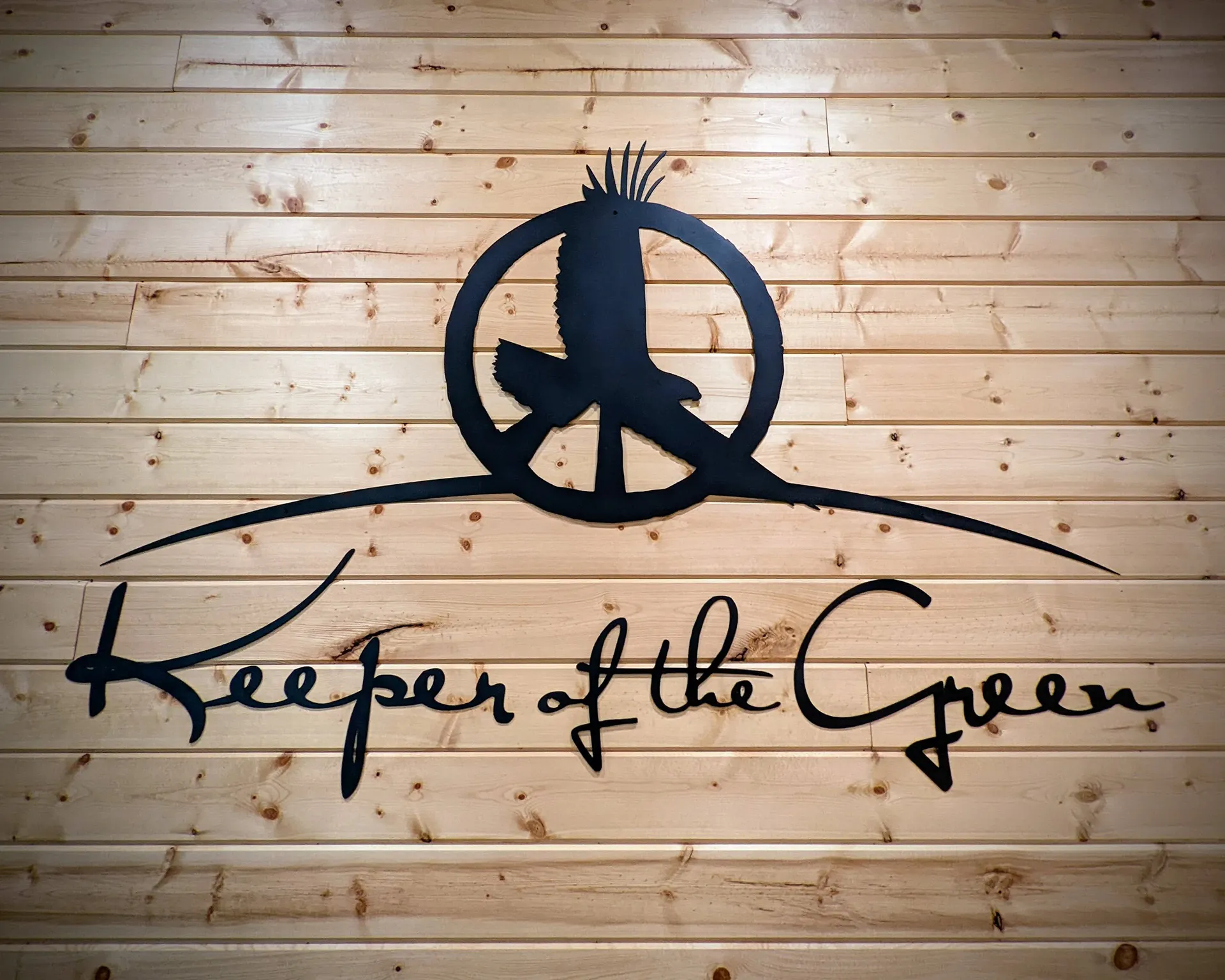 Keeper of the Green logo cut into a wooden wall sign